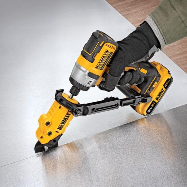 A person wearing a glove is using a yellow and black DEWALT DT70620 power tool to cut a sheet of metal. The tool is battery operated and features a cutting attachment for precision work.